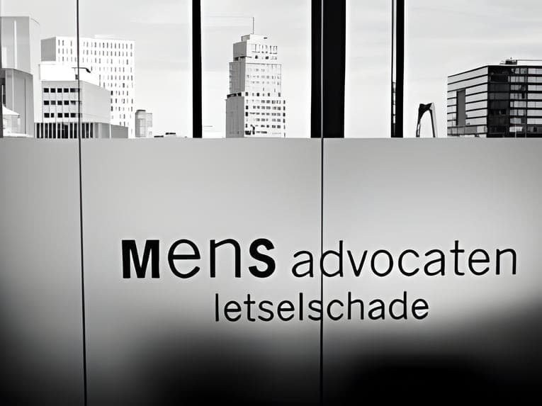 Glazen kantoorwand met de letters mens advocaten letselschade, met daarachter de skyline van Rotterdam
