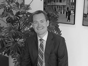 Portret van Paul Meijer in pak met stropdas, op kantoor